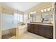 Modern bathroom with a glass-enclosed shower, soaking tub, and dual sink vanity at 8404 Romantic Sunset St, Las Vegas, NV 89131