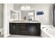 Modern bathroom featuring double sinks, granite countertops, large mirror, and relaxing soaking tub at 9138 Sea Mink Ave, Las Vegas, NV 89149