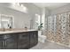 Bright bathroom boasts double sinks, black cabinetry, decorative mirror, and tiled floors at 9138 Sea Mink Ave, Las Vegas, NV 89149