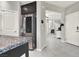View of kitchen leading to hall, featuring stainless steel refrigerator and granite countertop at 9138 Sea Mink Ave, Las Vegas, NV 89149