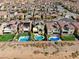 This aerial view shows a modern community with houses featuring backyard pools at 9607 Starfish Reef Way, Las Vegas, NV 89178