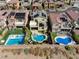 An aerial view of a backyard oasis with pools surrounded by green landscaping and outdoor lounging areas at 9607 Starfish Reef Way, Las Vegas, NV 89178