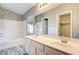 Bright bathroom features dual sinks, a bathtub with a shower, and a large mirror at 1073 Slate Crossing Ln # 1, Henderson, NV 89002