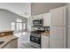 Bright kitchen with white cabinets, stainless steel appliances, and a view to the living area at 1073 Slate Crossing Ln # 1, Henderson, NV 89002