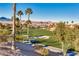 Scenic golf course view with lush green fairways, palm trees, and mountain views, plus a golf cart, perfect for outdoor recreation at 1080 Via Saint Lucia Pl, Henderson, NV 89011