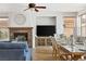 Open-concept living room with fireplace, TV, tiled floor, and elegant dining table with chairs at 1080 Via Saint Lucia Pl, Henderson, NV 89011