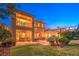 Expansive backyard featuring a lush lawn, elegant landscaping, and a charming two-story home at 11342 Winter Cottage Pl, Las Vegas, NV 89135