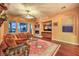 The cozy living room offers wood floors, a decorative ceiling fan, and a stone fireplace at 11342 Winter Cottage Pl, Las Vegas, NV 89135