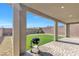 Covered patio with a barbecue grill overlooking the artificial grass backyard with low-maintenance landscaping at 12125 Arrebol Ave, Las Vegas, NV 89138