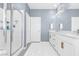 Modern bathroom featuring a double vanity with gold hardware and a glass enclosed shower at 12125 Arrebol Ave, Las Vegas, NV 89138