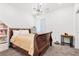 Cozy bedroom with a classic wood sleigh bed, soft carpet, and decorative light fixture at 12125 Arrebol Ave, Las Vegas, NV 89138