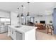 Bright, open kitchen with a large island, stainless steel appliances, and views into the dining area at 12125 Arrebol Ave, Las Vegas, NV 89138