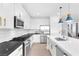 Bright kitchen features white cabinetry, stainless steel appliances, a large island and pendant lighting at 12125 Arrebol Ave, Las Vegas, NV 89138