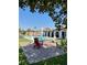 Inviting backyard with colorful Adirondack chairs on a brick patio, surrounded by lush artificial turf at 1780 Westwind Rd, Las Vegas, NV 89146