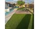 Relaxing backyard featuring a pool, sun loungers, artificial turf, and mature landscaping at 1780 Westwind Rd, Las Vegas, NV 89146