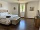 Bright bedroom featuring hardwood floors, a tufted headboard, and a bench near a sunny window at 1780 Westwind Rd, Las Vegas, NV 89146