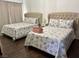 Bedroom featuring two beds with cushioned headboards, floral bedding, and hardwood floors at 1780 Westwind Rd, Las Vegas, NV 89146