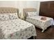 Bedroom featuring two beds with cushioned headboards, floral bedding, and hardwood floors at 1780 Westwind Rd, Las Vegas, NV 89146
