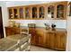 Eat-in kitchen featuring wood cabinetry, glass displays, and farmhouse decor at 1780 Westwind Rd, Las Vegas, NV 89146
