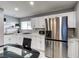 Well-lit kitchen with stainless steel refrigerator, white cabinetry, and modern countertops at 1780 Westwind Rd, Las Vegas, NV 89146