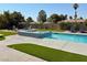 Backyard oasis featuring a pool, hot tub, and artificial grass at 1780 Westwind Rd, Las Vegas, NV 89146