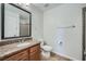 Bathroom featuring a granite countertop vanity, tile floors, and a framed mirror in a well-lit area at 1810 N Decatur Blvd # 201, Las Vegas, NV 89108