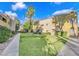 Apartment building with a grassy lawn, mature landscaping, and a walkway at 1810 N Decatur Blvd # 201, Las Vegas, NV 89108