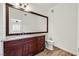 Bathroom featuring a large mirror, granite countertops, and dark wood cabinets at 1830 N Buffalo Dr # 2106, Las Vegas, NV 89128