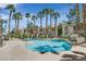 Inviting community pool area featuring lounge chairs, shade structures, and lush palm tree landscaping at 1830 N Buffalo Dr # 2106, Las Vegas, NV 89128