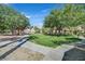 Green space with lush grass, mature trees, sidewalks, and covered picnic tables at 1830 N Buffalo Dr # 2106, Las Vegas, NV 89128