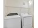 Clean laundry room includes a white washer and dryer, plus wire rack shelving for storage at 1830 N Buffalo Dr # 2106, Las Vegas, NV 89128