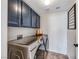 Laundry room with stainless steel washer and dryer and blue storage cabinets at 184 Timeless View Ct, Henderson, NV 89012