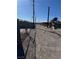 Back alley with chain link fence and an empty, sunlit alley at 2043 Donna St, North Las Vegas, NV 89030