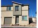 Two-story tan home with a one-car garage, neutral trim, and a brick walkway at 2734 Champagne Gold Ave, North Las Vegas, NV 89086