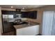 Modern kitchen with stainless steel appliances, granite countertops, and dark wood cabinets at 2734 Champagne Gold Ave, North Las Vegas, NV 89086