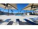 Community pool with lounge chairs, umbrellas, palm trees, and clear blue skies at 2734 Champagne Gold Ave, North Las Vegas, NV 89086