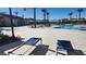 Community pool with lounge chairs, umbrellas, palm trees, and clear blue skies at 2734 Champagne Gold Ave, North Las Vegas, NV 89086
