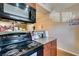 Electric range stove is in a kitchen with granite countertops and wood cabinets at 2750 S Durango Dr # 2012, Las Vegas, NV 89117