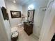 A bathroom featuring a dark wood vanity with brass hardware and an ornate framed mirror over a neutral tile floor at 3341 Camino Gardens Way, Las Vegas, NV 89146