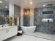 Modern bathroom with a freestanding tub, chandelier, tiled accent wall, and white vanity at 3341 Camino Gardens Way, Las Vegas, NV 89146