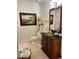 A bathroom featuring a dark wood vanity with brass hardware and an ornate framed mirror over a neutral tile floor at 3341 Camino Gardens Way, Las Vegas, NV 89146