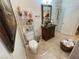 A bathroom featuring a dark wood vanity with brass hardware and an ornate framed mirror over a neutral tile floor at 3341 Camino Gardens Way, Las Vegas, NV 89146
