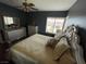 A bedroom features black painted walls with gold accents from the mirror and pillows to the luxurious bedding at 3341 Camino Gardens Way, Las Vegas, NV 89146
