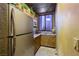 Compact kitchen featuring wood cabinets, stainless-steel refrigerator, and decorative plants at 3341 Camino Gardens Way, Las Vegas, NV 89146