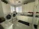 Bright laundry room with white cabinets, modern appliances, and stylish laundry accessories at 3341 Camino Gardens Way, Las Vegas, NV 89146