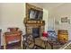 Cozy living area with a stone fireplace, TV, and comfortable seating, perfect for relaxation at 3341 Camino Gardens Way, Las Vegas, NV 89146