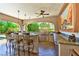 Built-in outdoor kitchen featuring stainless steel appliances and barstool seating overlooking the backyard at 3341 Camino Gardens Way, Las Vegas, NV 89146