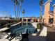 Backyard pool with a covered patio and lounge chairs for enjoying the sunny weather with tropical palm trees at 3341 Camino Gardens Way, Las Vegas, NV 89146