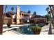 Luxurious backyard pool and patio area surrounded by lush greenery and an exterior of the home with large windows at 3341 Camino Gardens Way, Las Vegas, NV 89146