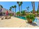 Swimming pool with patio table, lush greenery and mature palm trees around the perimeter at 3341 Camino Gardens Way, Las Vegas, NV 89146
